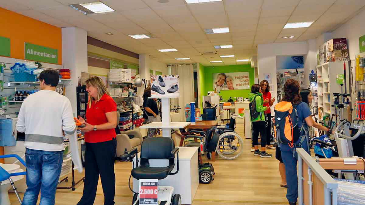 Tienda abuelo actualFotografía del interior de la tienda con varias personas atendiendo y recibiendo asesoramiento. Se ven clientes y personal ...