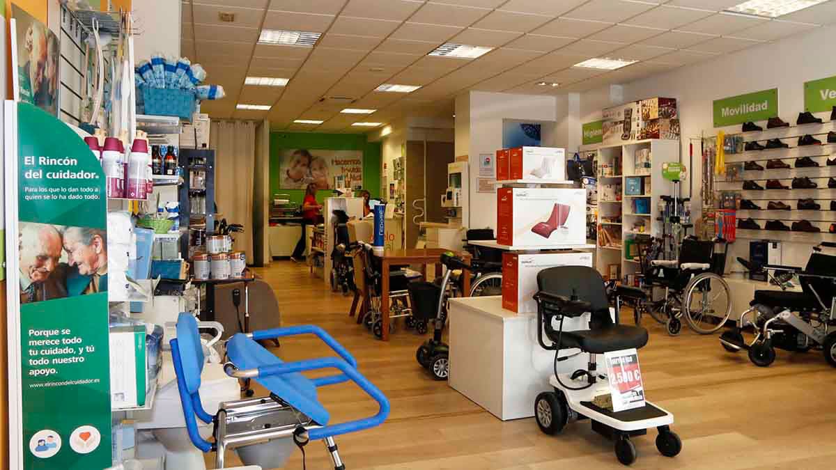 Imagen del interior de una tienda amplia y bien iluminada dedicada a productos de apoyo y movilidad. En primer plano se observan ayudas técnicas ...