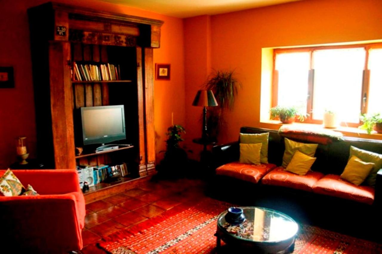 Intérieur du salonL’image montre l’intérieur d’un salon de style rustique avec des murs peints en orange profond et un sol en carreaux de terre ...
