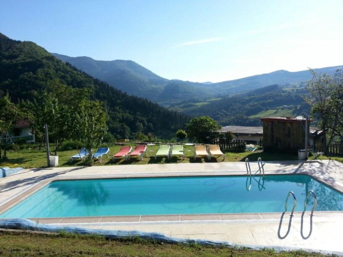 L’image montre une piscine extérieure rectangulaire à l’eau bleu cristal, située dans un cadre naturel de montagne sous un ciel dégagé. Au premier ...